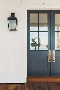 a blue front door with two sidelights and a light on the wall next to it