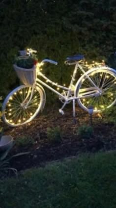 a bicycle is decorated with christmas lights in the yard