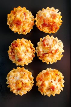 six small cups filled with food on top of a black surface and the words hot brown bites above them