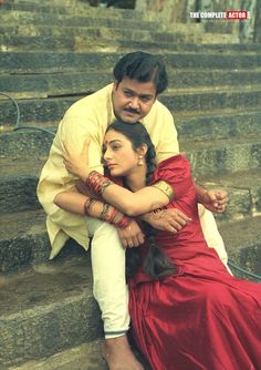 a man and woman sitting on some steps