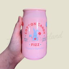 a hand holding a pink can of cotton candy