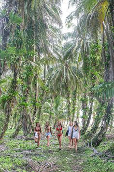 four women walking through the jungle in bikinis