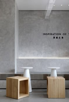 three white pedestals in front of a wall with the words inspiration of time written on it