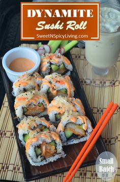 sushi rolls with sauce and chopsticks on a tray next to a drink