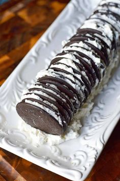 an ice cream and chocolate dessert on a white platter sitting on a wooden table