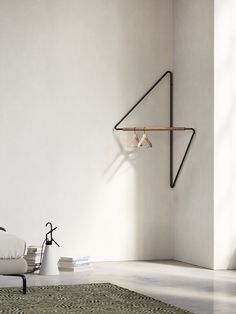 a white room with a shelf and some books on the floor next to a lamp