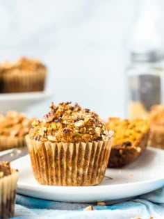 a muffin on a white plate with other muffins in the back ground