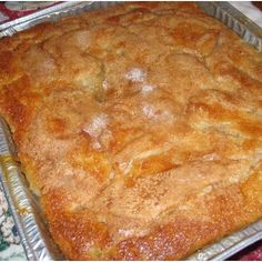 a casserole in a pan on top of a floral table cloth with a knife