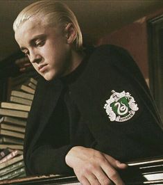 a man with blonde hair sitting at a piano