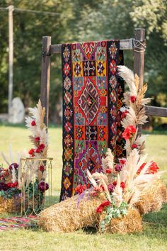 an outdoor area with hay, flowers and rugs