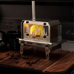 a toaster oven sitting on top of a wooden cutting board next to coffee beans