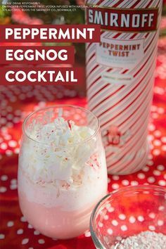 two glasses filled with white liquid sitting on top of a red table cloth next to a bottle