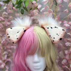 a wig with pink hair and black polka dots on the ears is shown in front of flowers