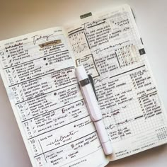 an open planner with a pen on top