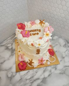 a birthday cake with flowers and the words happy new year on it sitting on a table