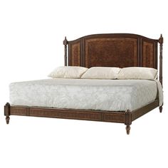 a large bed with wooden headboard and foot board on top of the bed frame