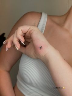 a woman with a small tattoo on her left arm, holding onto the other arm