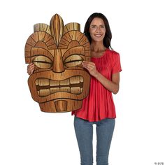 a woman holding a wooden mask in front of her face