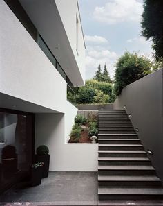 the stairs lead up to the upper level of this modern house, which has been designed in white and black