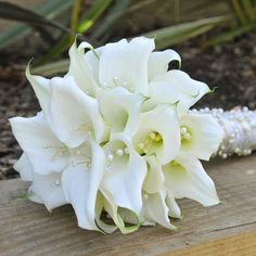 a bouquet of white flowers sitting on top of a wooden table