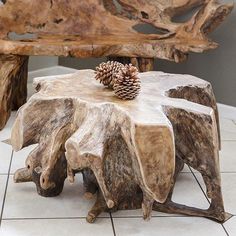 a wooden bench made out of logs with a pine cone on top