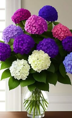 a vase filled with purple, white and pink flowers on top of a wooden table