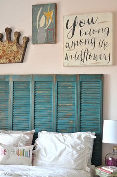 a bed with blue shutters and pictures on the wall