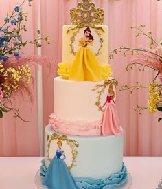 there is a three tiered cake with princesses on it