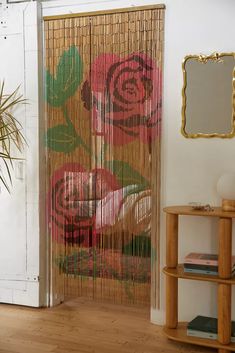 a room with a wooden floor and a bamboo curtain that has flowers painted on it