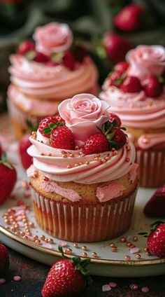 cupcakes with pink frosting and strawberries on a plate