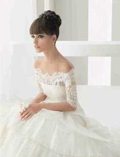 a woman in a white wedding dress sitting on a chair with her hand on her knee