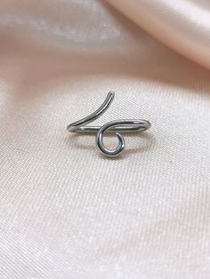 a silver ring sitting on top of a white cloth