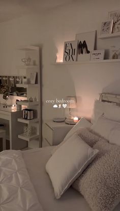 a bedroom with white bedding and lots of pillows