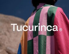 the back of a person wearing a pink, green and yellow striped jacket with words tucumca on it