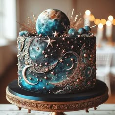 a blue cake with stars and moon designs on it's side, sitting on a table