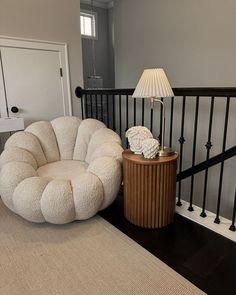 a chair and lamp sitting on top of a wooden floor next to a stair case