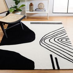 a black and white area rug in a living room with a wicker chair next to it