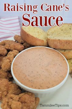 a white plate topped with fried food and dipping sauce next to two pieces of bread