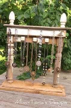 a wooden stand with jewelry hanging from it's sides