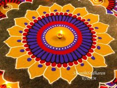 a candle is lit in the center of a colorful rangolite design on top of a table