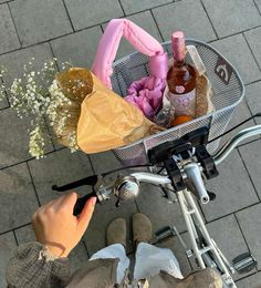 a person riding a bike with a basket full of bottles and soaps on it