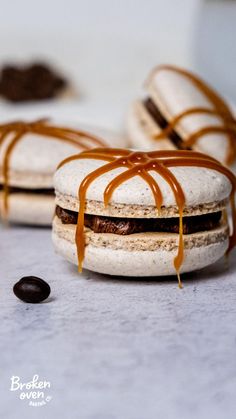 three cookies with chocolate fillings on top of each other and drizzled with caramel