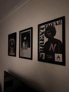 three black and white posters hang on the wall