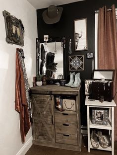 a room with a dresser, mirror and pictures on the wall