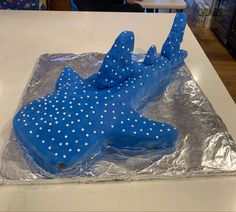 a blue cake with white polka dots on it sitting on top of a countertop