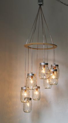 mason jar chandelier with lights hanging from it's sides in a room