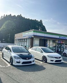 three white cars parked in front of a building