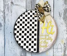 a wooden plaque with a black and white checkerboard design on it, that says hi we are probably at the grade