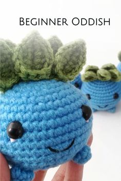 a crocheted blue stuffed animal with green leaves on it's head