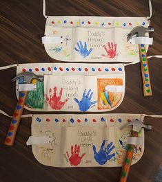 two children's handprinted aprons with tools attached to them